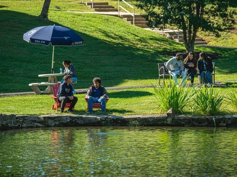 students sitting in front of Lares pond